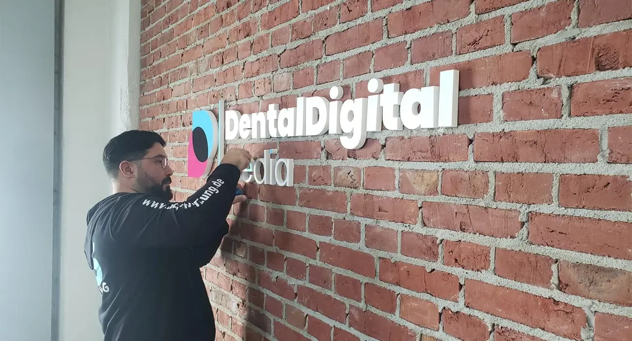 Montage weißer Einzelbuchstaben an einer Backsteinwand