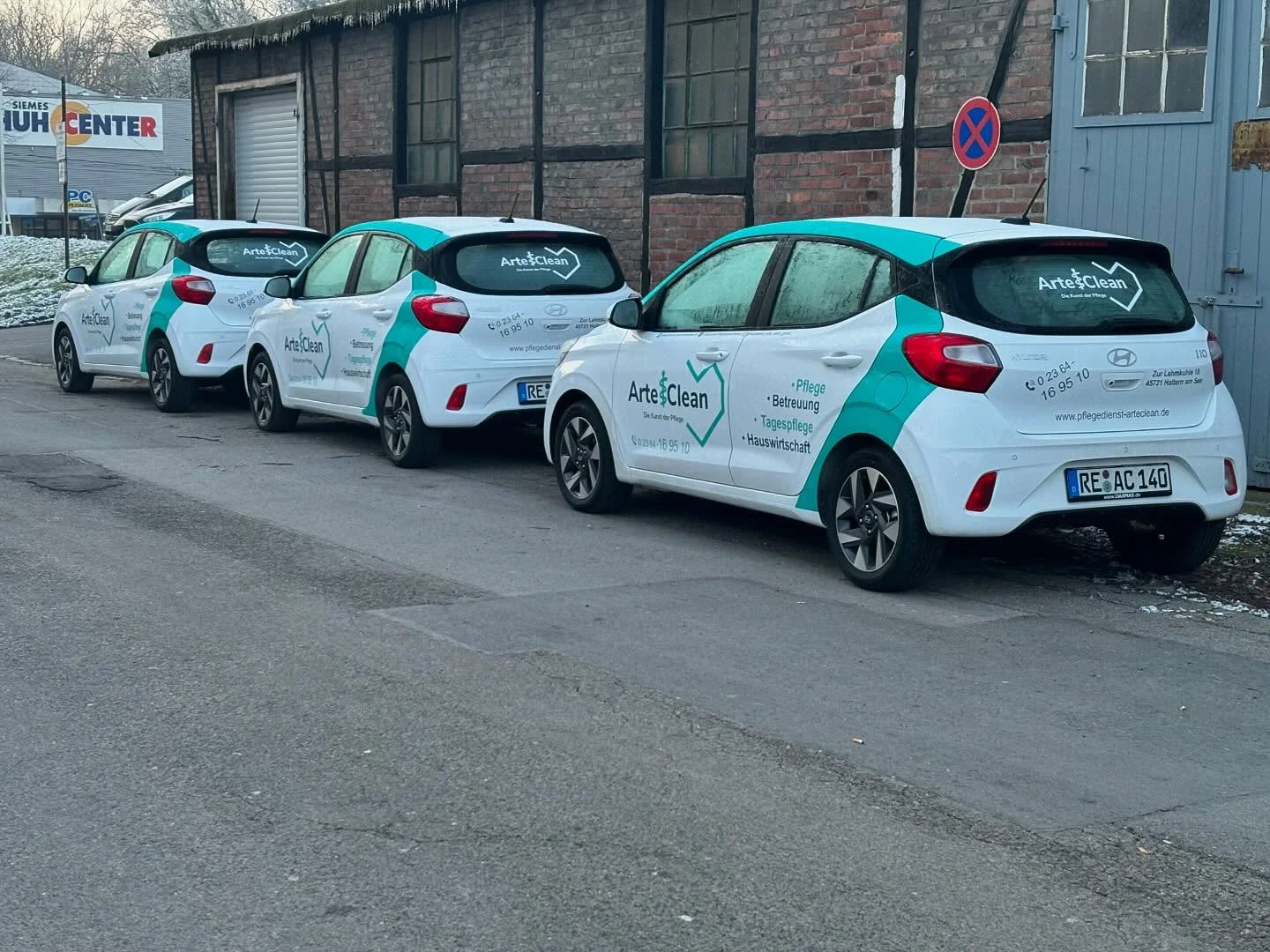 Beschriftete weiße Fahrzeuge von Arte Clean mit türkisfarbenen Markenelementen