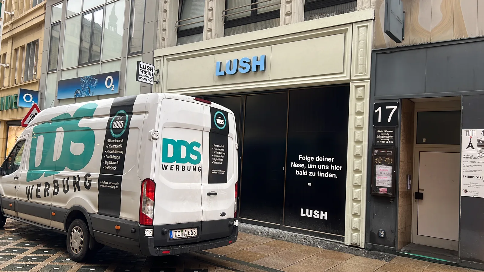 LUSH-Schriftzug über einer Ladenfront mit DDS-Fahrzeug davor